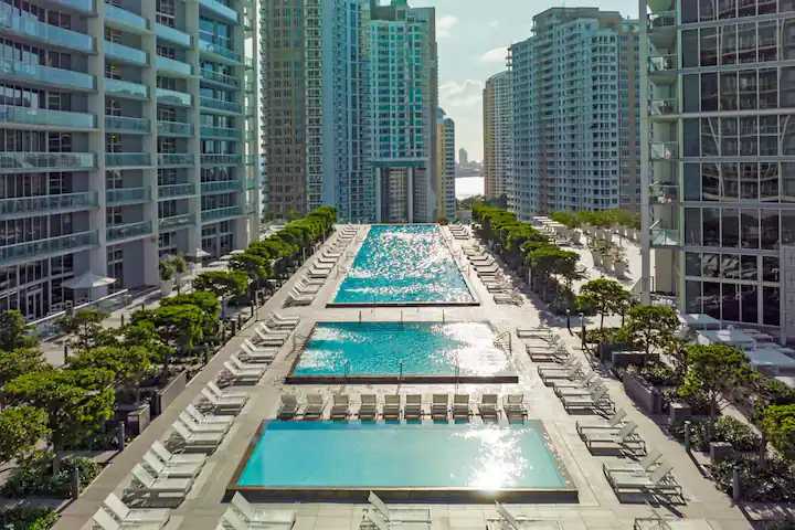 The resort-style pool deck lined with loungers and palms at Icon Brickell