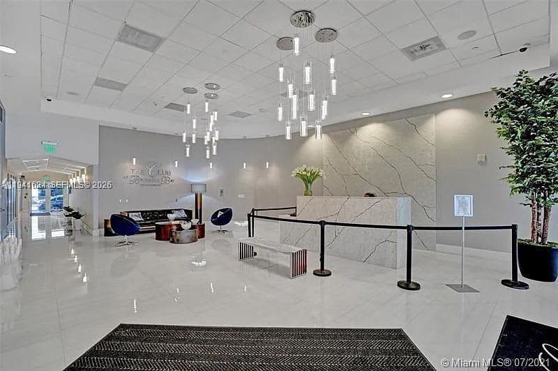 Lobby with a reception desk and pendant lights.