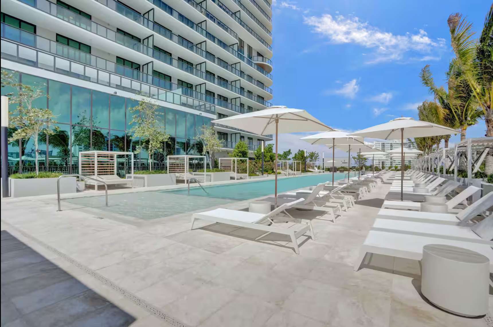 Luxury poolside layout with umbrellas and direct tower views.