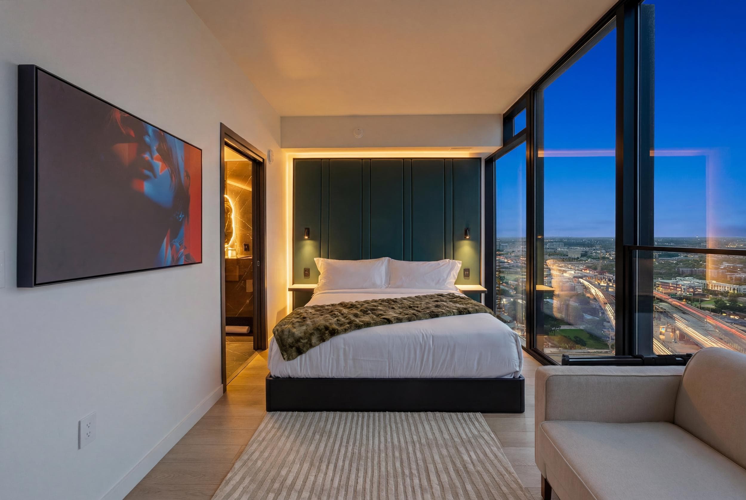 Luxurious bedroom with stunning high-rise city night views.